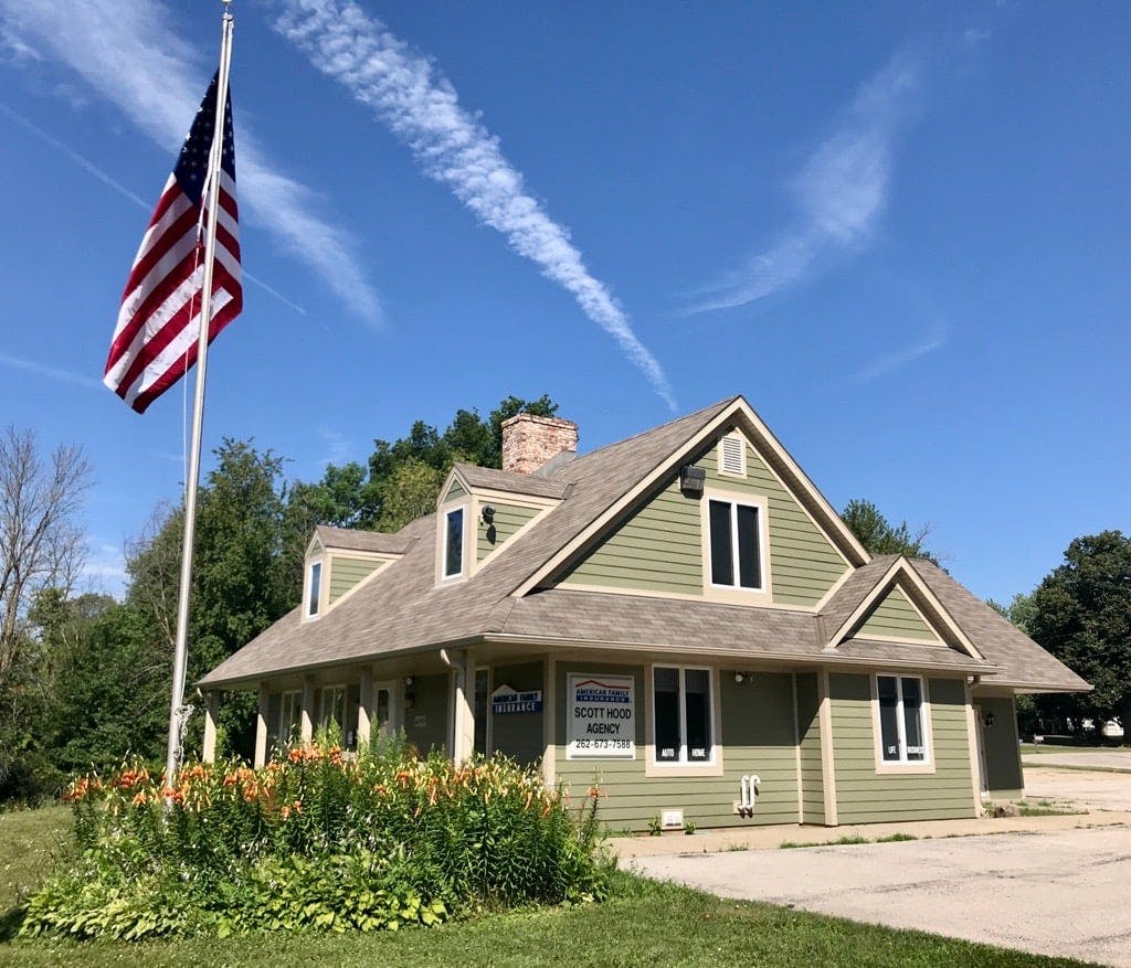 a house with a flagpole and a flag in front of it